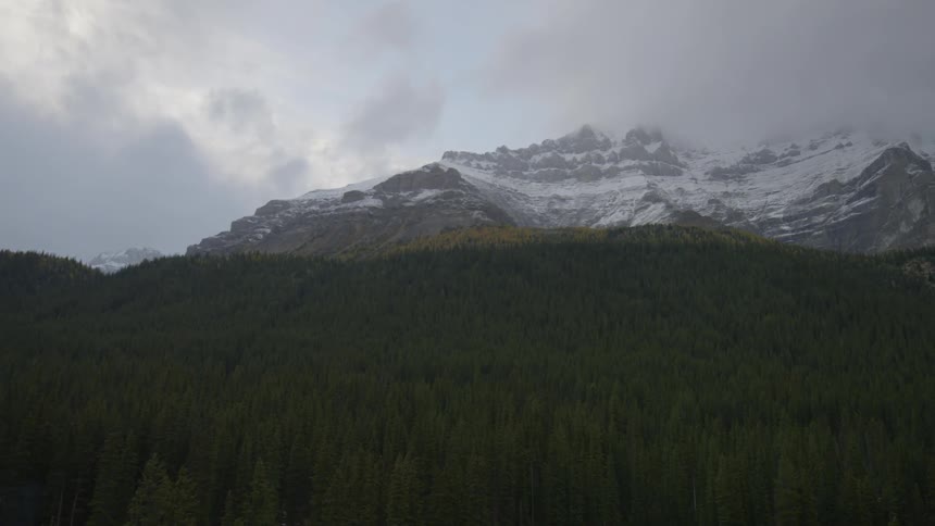 The tall mountain has snow on it's peak