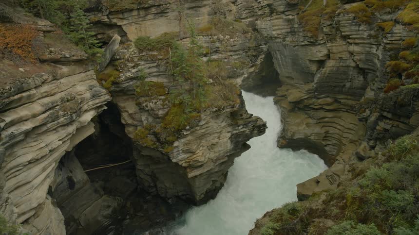 The water is rushing along the canyon below