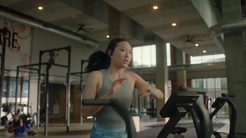 A young asian woman is working out legs on equipment in the gym