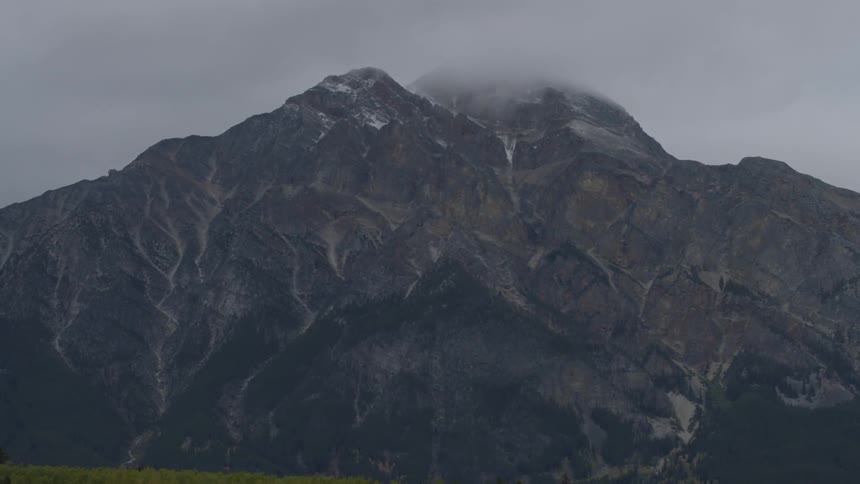 The clouds are touching the very top of the mountain