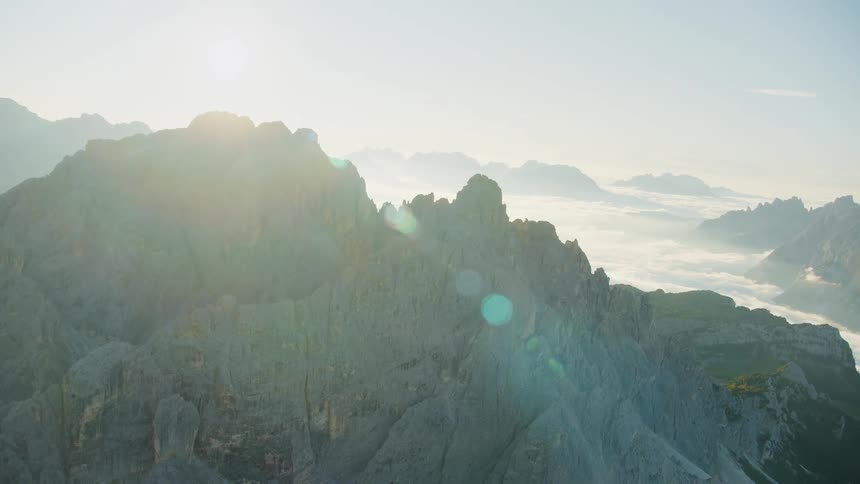 Aerial of a rocky mountain with clouds covering the landscape