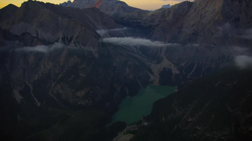 A valley with a lake at the base of rocky mountains