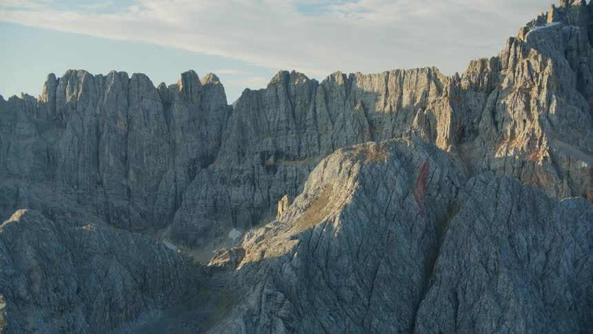 Rainbow effect hovers over jagged mountains in mountain range