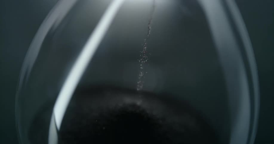 Hourglass with black sand falling