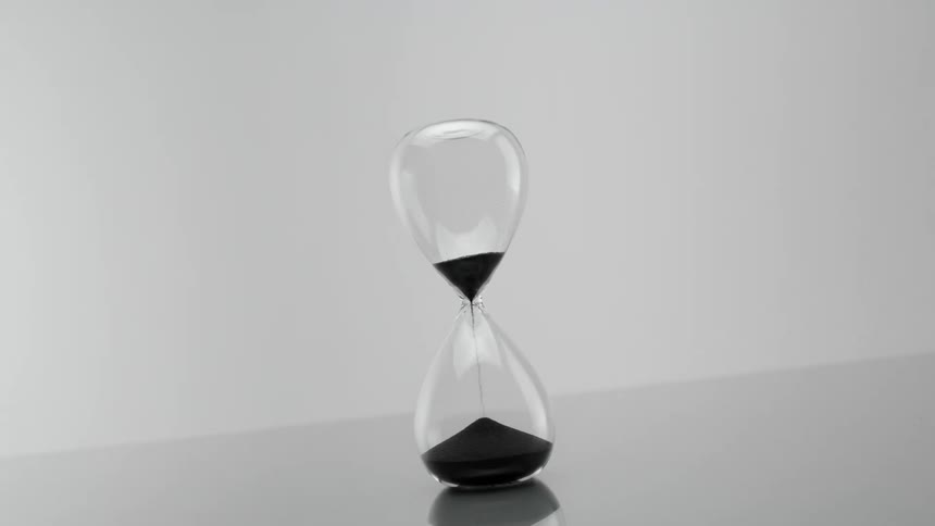 Hourglass with black sand falling