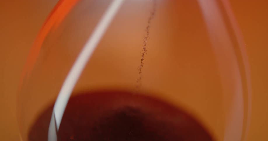 An hourglass with its grains of sand falling