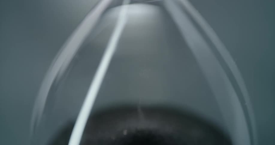 Hourglass with black sand falling