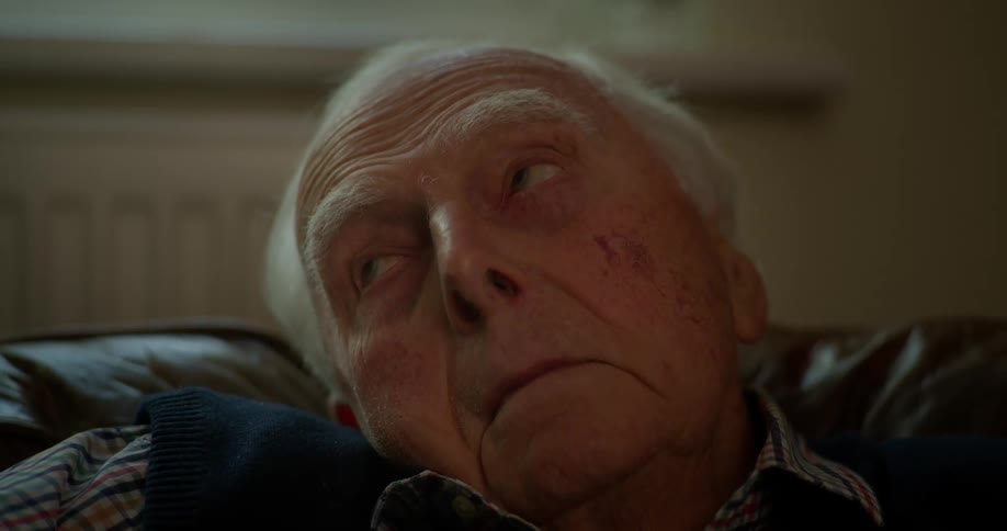 An elderly man lying on the sofa