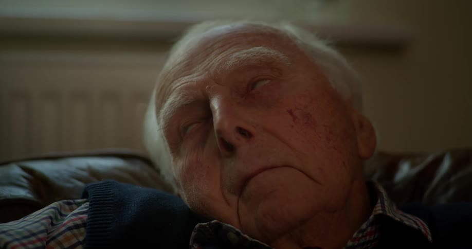 Close up of an elderly man sleeping in an armchair