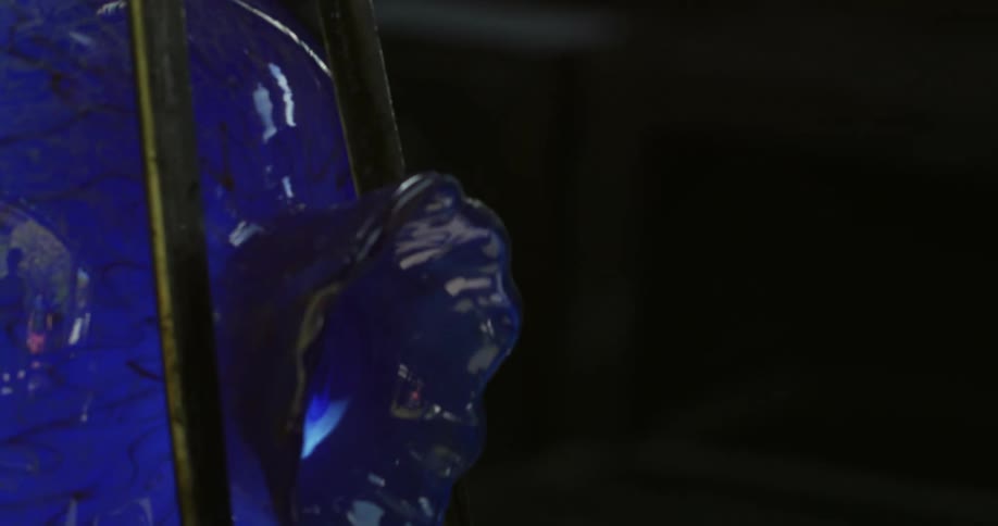 Metal thong shapes the neck of a piece of blue glassware