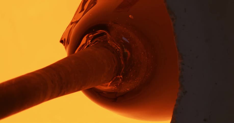 Molten glass spinning inside a hot furnace