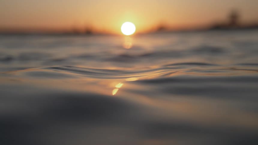 Small water waves near a coast at sunset
