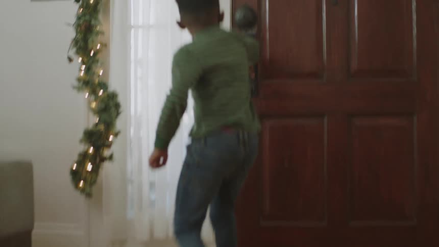 Boy running toward the door and opening it