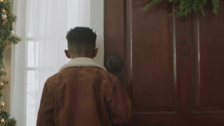Boys running towards the door indoors with their backs turned