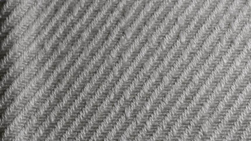 Extreme closeup on a piece of clothing with white threads