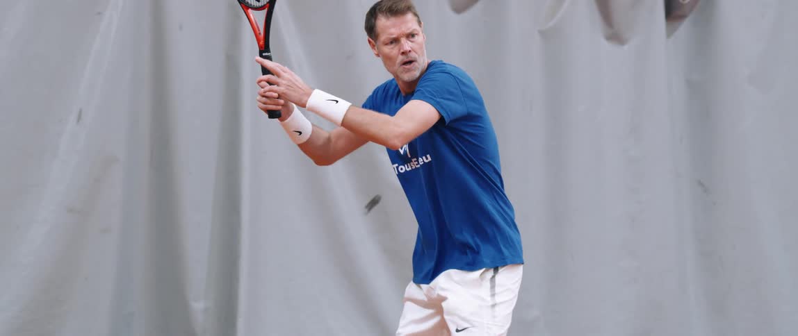 A man smashing a tennis ball with his racket