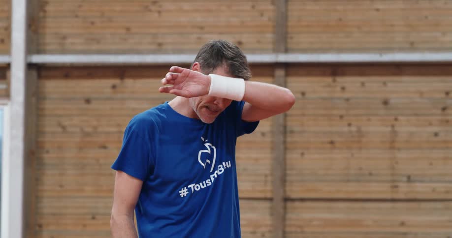 Tennis player bounces on his feet and wipes his sweat