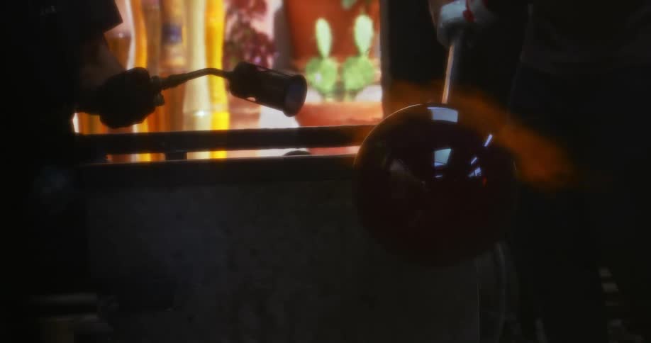 Blowtorch emitting flames onto a crystal vase mold