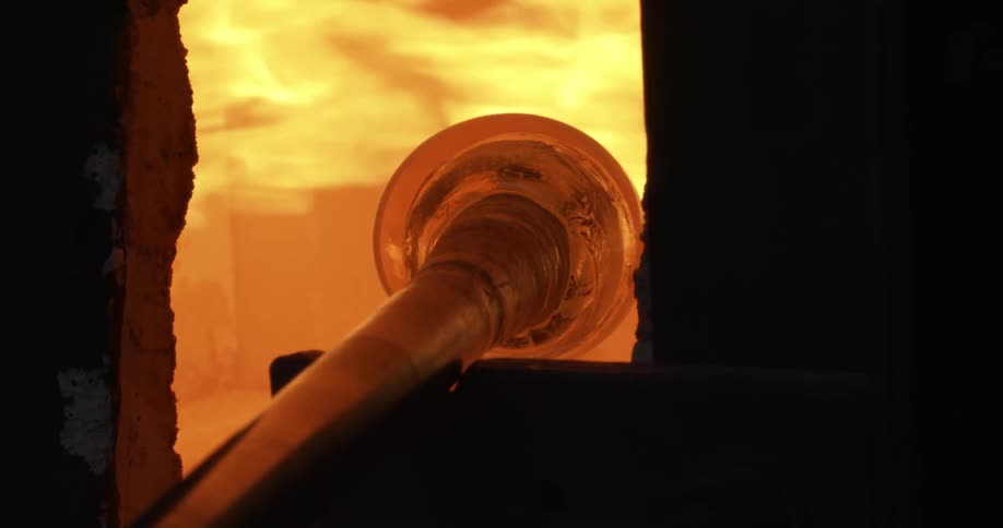 Glass turns on pole in glass furnace during glass making