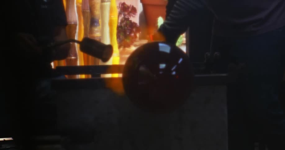 Workers shaping a glass sphere into crystal with fire