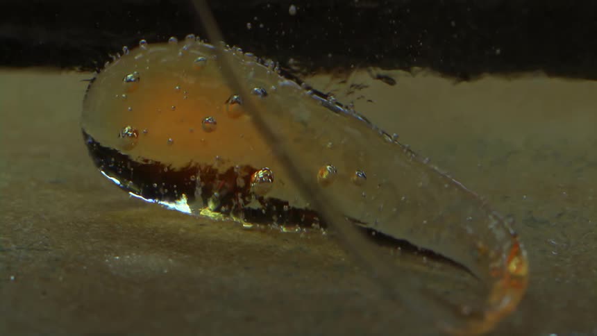 A drop of hot glass under the water is boiling the water and making lots of bubbles
