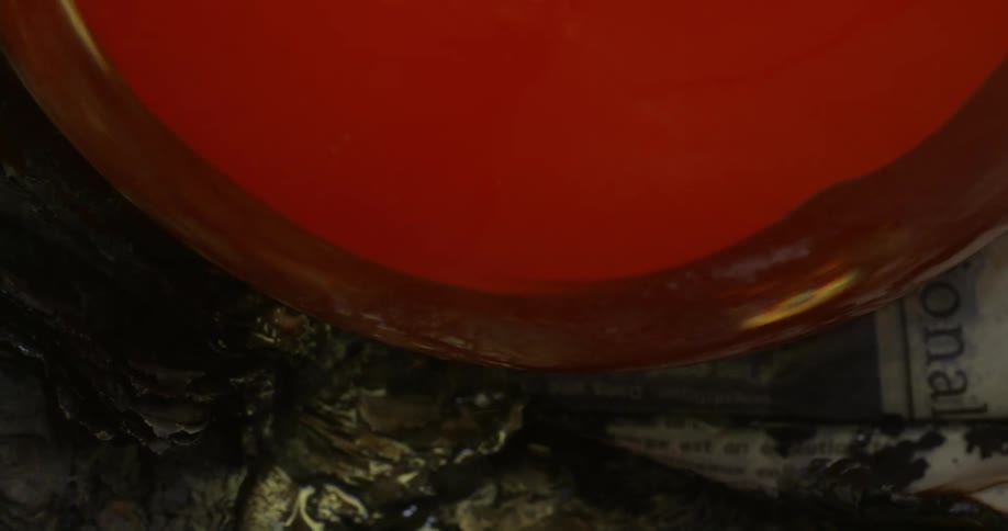 A glass that is hot is melting and liquid is falling from it