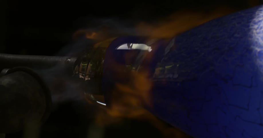 The production of a blue glass vase with fire being expelled