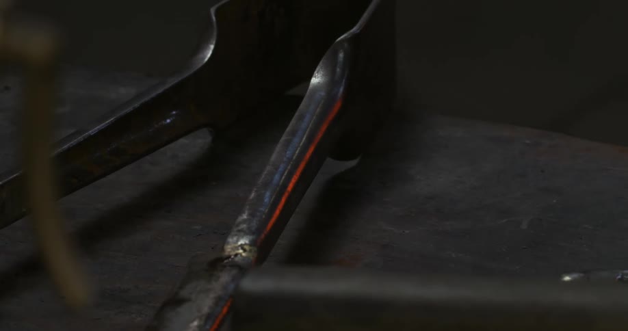 A small iron tool on a rusty table