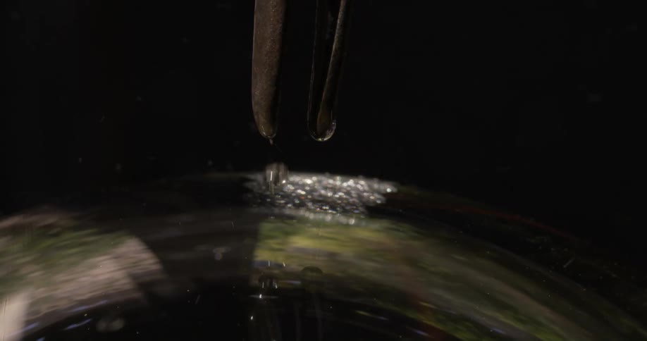 Closeup of a tool encountering glass and generating small water bubbles