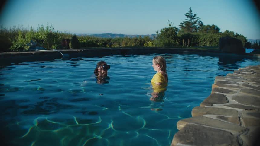 Two women in the pool getting ready to hold their breath underwater