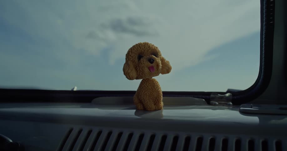 A dog bobble head is on the dashboard
