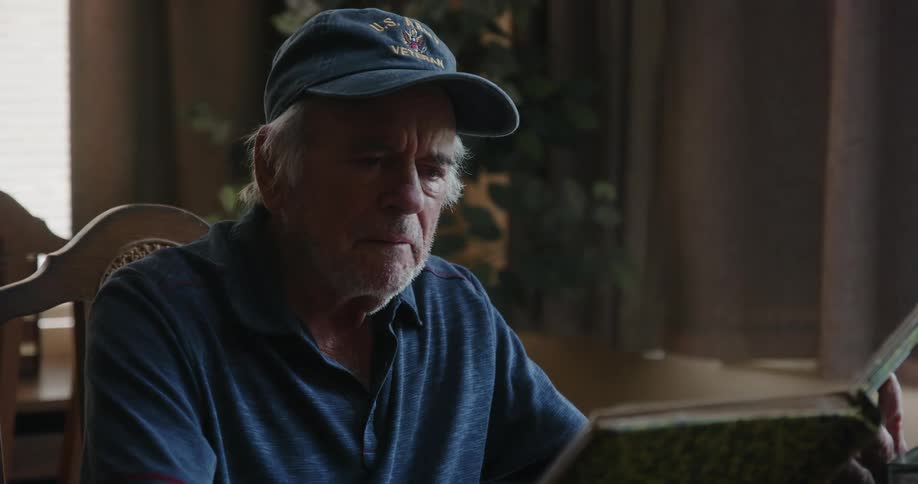 Man stops to remember while looking at a photo album