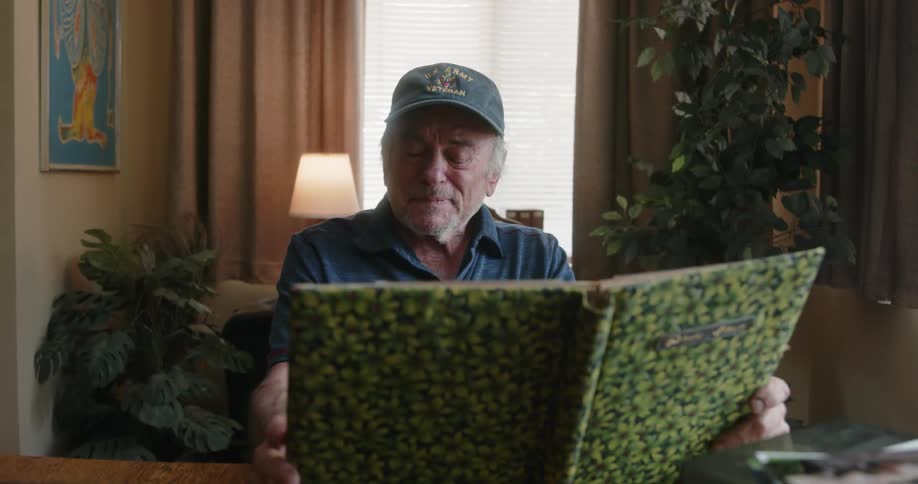 A man is smiling as he flips through a photo album