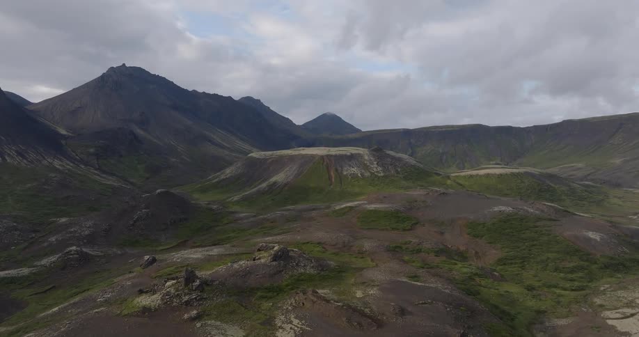 A mountain range with lots of dirt mud and some greenery