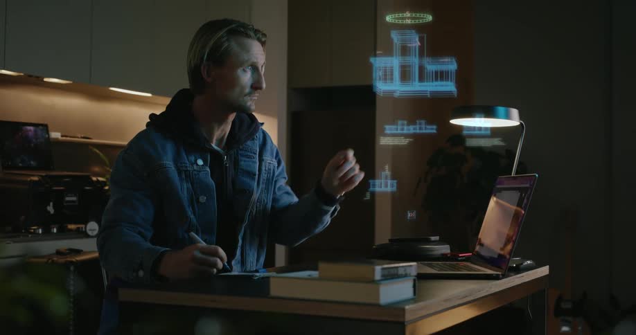 A man takes notes while looking at a hologram