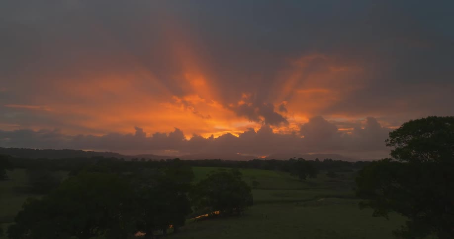 Sunlight filters through the clouds at sunset in the countryside