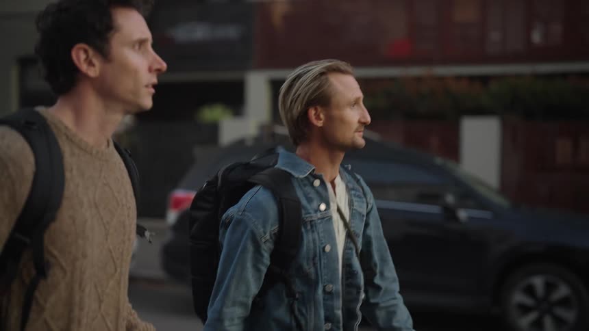 Two men walking on the city street and talking