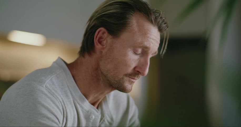 A man deep in thought after typing on a laptop indoor