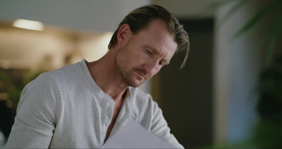 A man uses his laptop while looking at a document