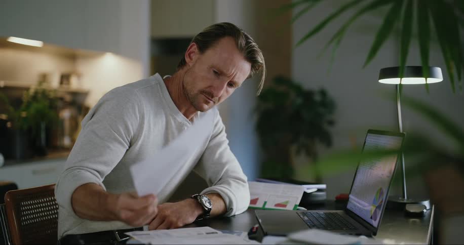 A man is reading a document at his desk