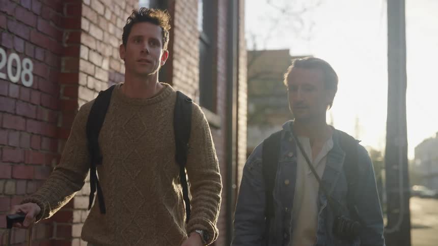 Two men walking on a street and conversing