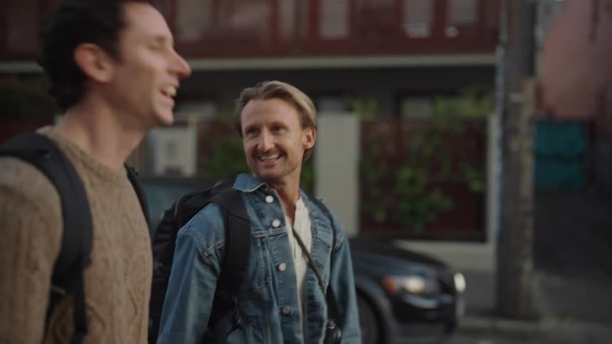 Two tourists talk and laugh as they walk