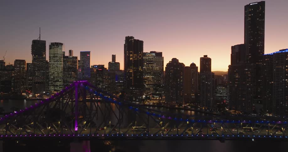 Cars travel over the brightly lit bridge in the city