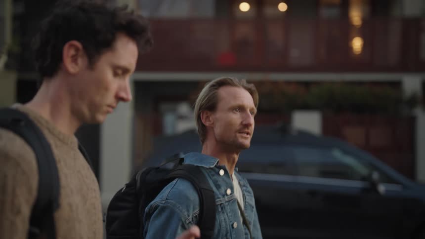 Two men talk and walk through the city exploring while talking