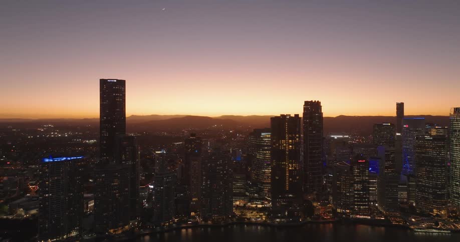 Aerial view of a metropolis by the seaside with a reddish evening sky
