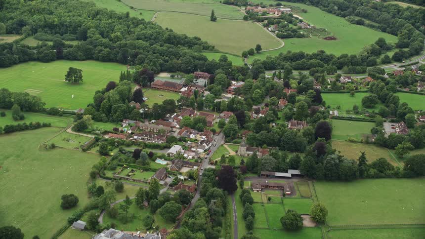 A small village with a few houses in the middle of vast fields of grass