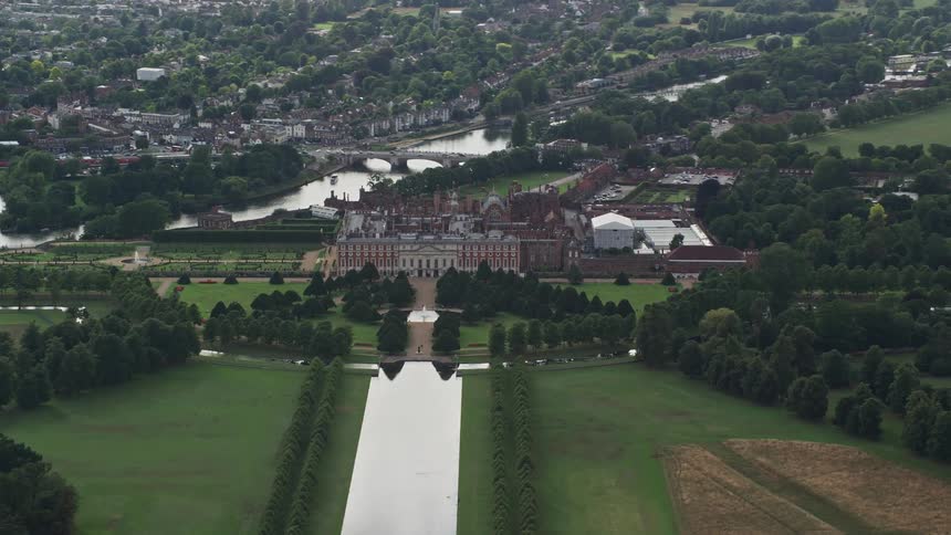 Aerial view of a castle with a central lake in a lushly vegetated environment