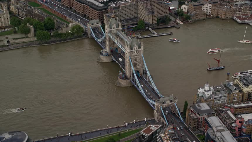 Buildings suspension bridge boats and moving cars in a metropolitan area