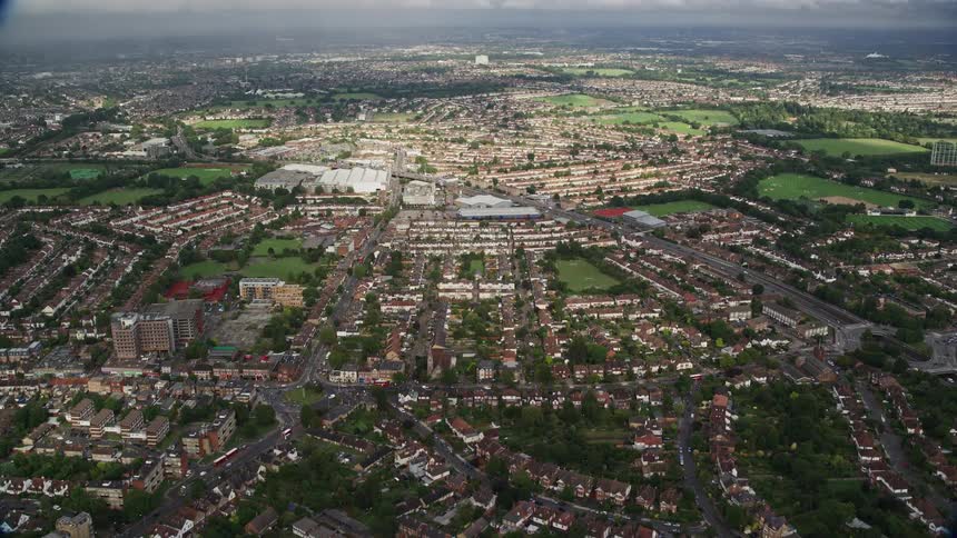 A residential neighborhood with buildings surrounded by lush green vegetation streets with cars passing by and a pleasant road view