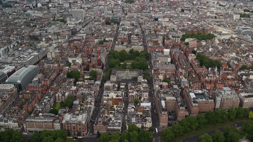 A city close to an open field with green vegetation